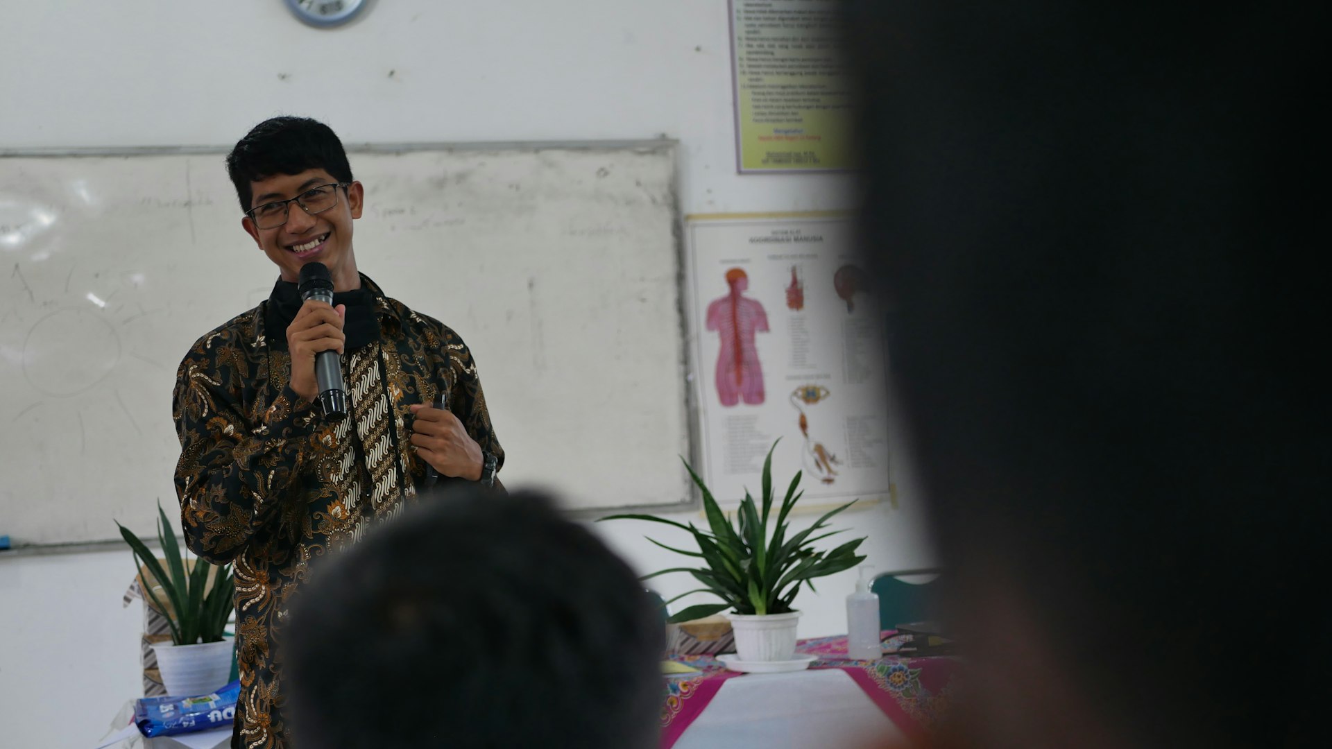 a man standing in front of a mirror holding a microphone